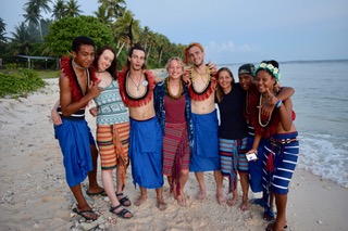 a group of ucsc students with some ulithi students on a sandy white beach